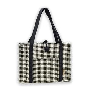 Front view of KONA CAVE® luxury Travel Dog Bed in Black and White Houndstooth with black faux suede lining, with front pocket. Portable folded dog mat with leather shoulder straps, and toggle closure for restaurants, pubs and hotels. 