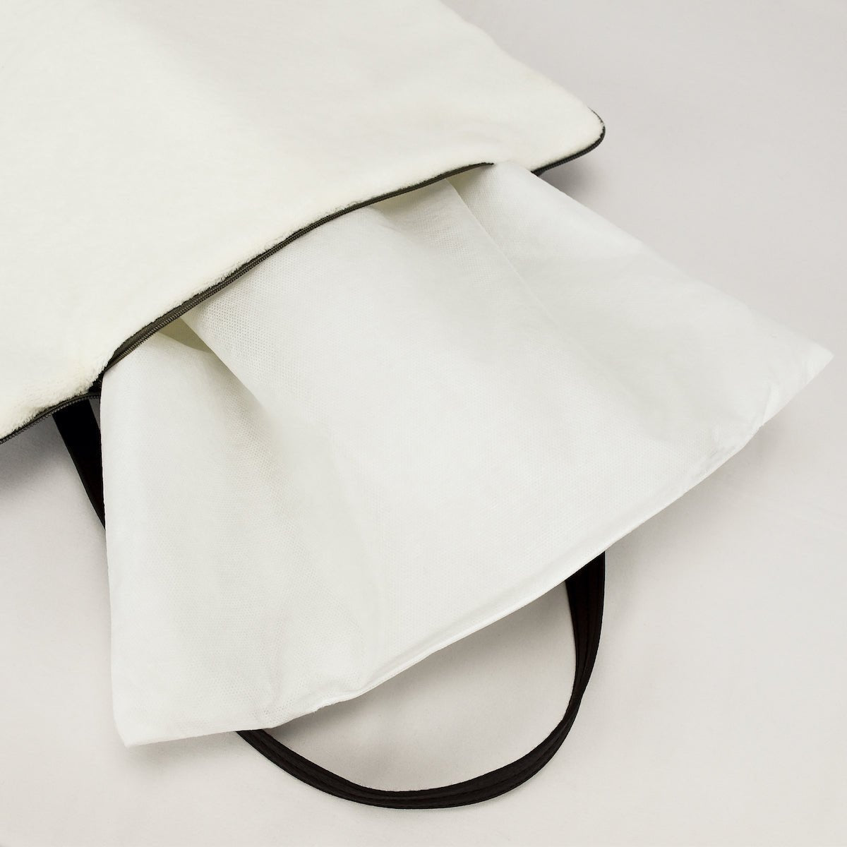 Portable dog bed. Folded, zips closed. Carried by long shoulder straps, handles. Ideal for restaurants, travel and parks. Filled with thick batting.
