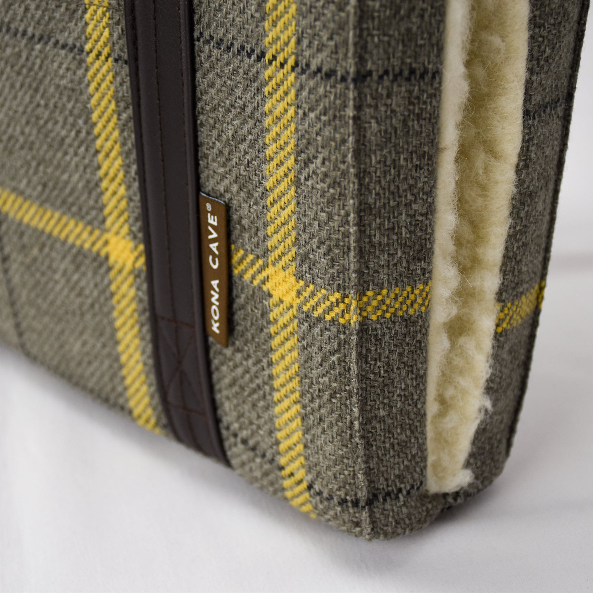 Close up of the beige and gold semi-stain resistant designer fabric and real shearling wool lining on the KONA CAVE® Travel Dog Bed